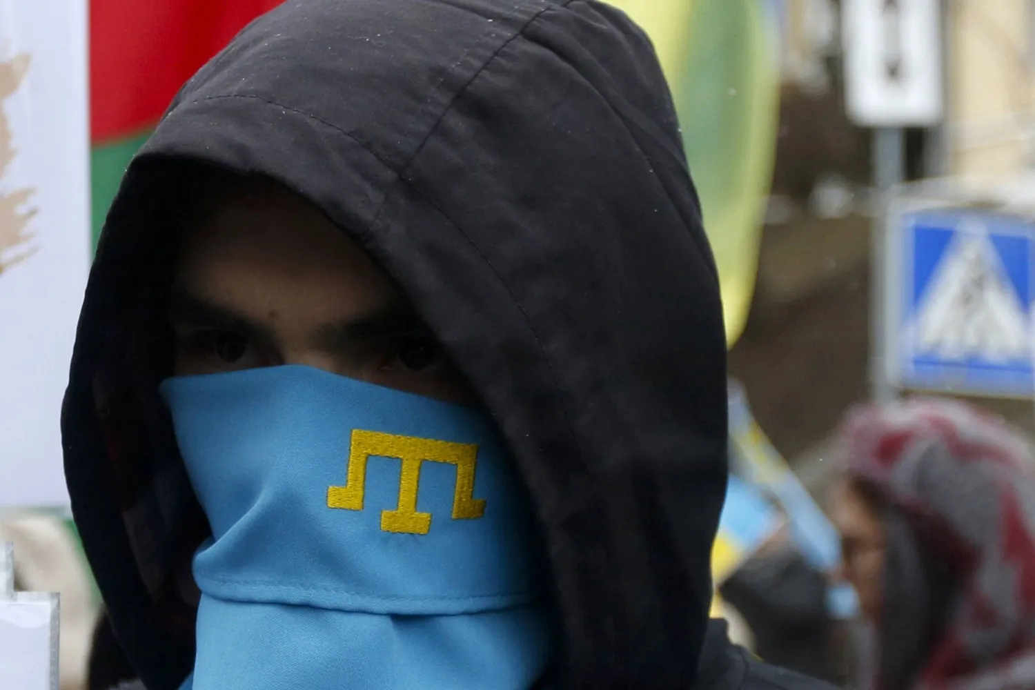 ناشط يرتدي وشاحاً عليه رمز تتار القرم أثناء حضوره مسيَّرة ضد ضم روسيا لشبه جزيرة القرم في العاصمة الأوكرانية كييف عام 2017 (أ.ب)