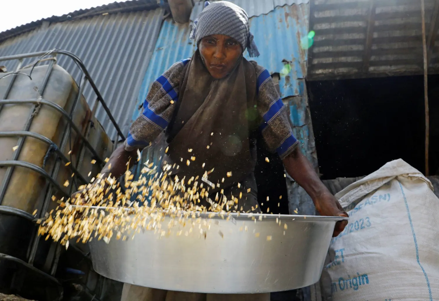 امرأة في الصومال تحصل على حصتها من القمح المستورد من أوكرانيا في سوق باكارا المفتوحة بمقديشو (رويترز)