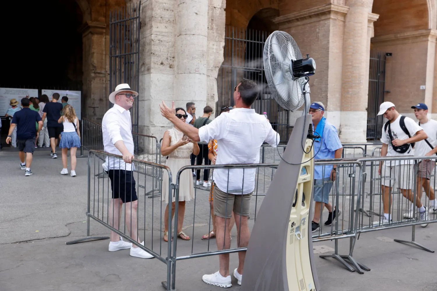 أشخاص يقفون بالقرب من الكولوسيوم في روما (رويترز)