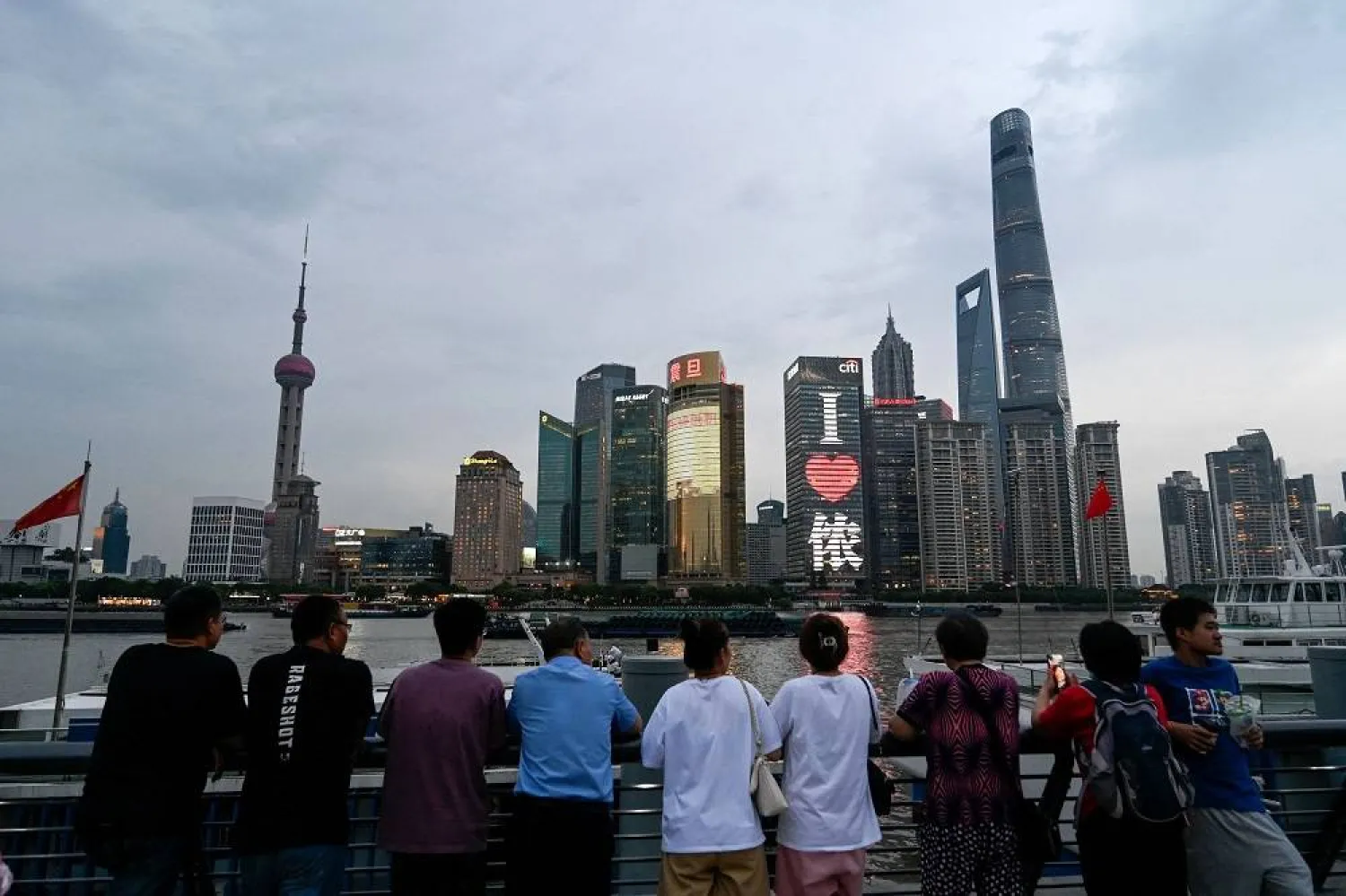 People are seen visiting the Bund promenade along the Huangpu river at the Huangpu district in Shanghai on June 29, 2023. (AFP)