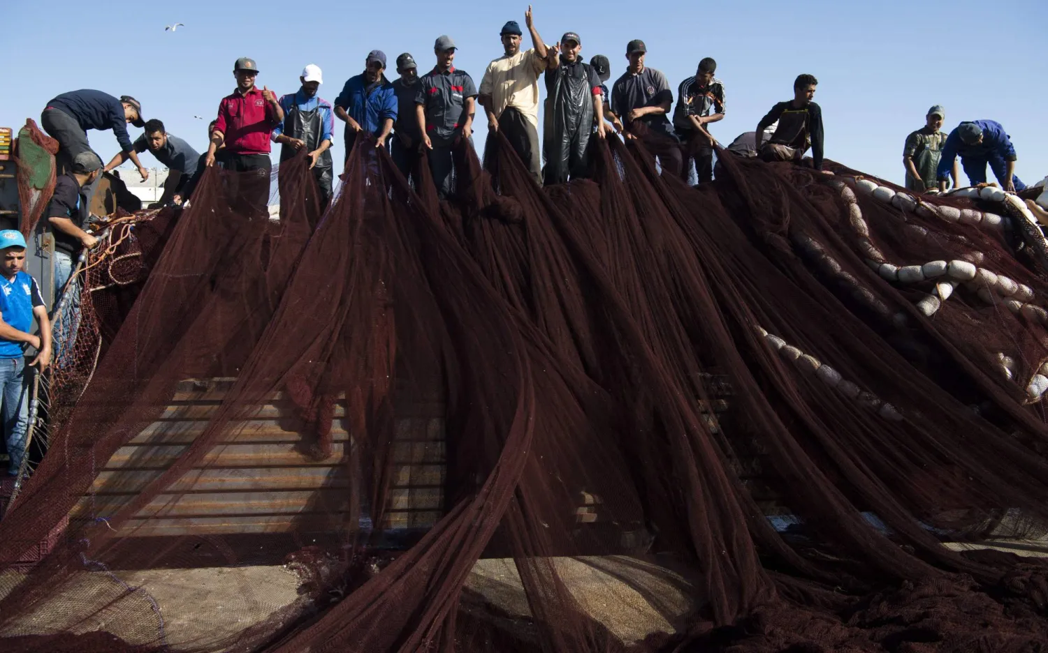 صيادون مغاربة داخل أحد مراكب الصيد في ميناء العيون (أ.ف.ب)