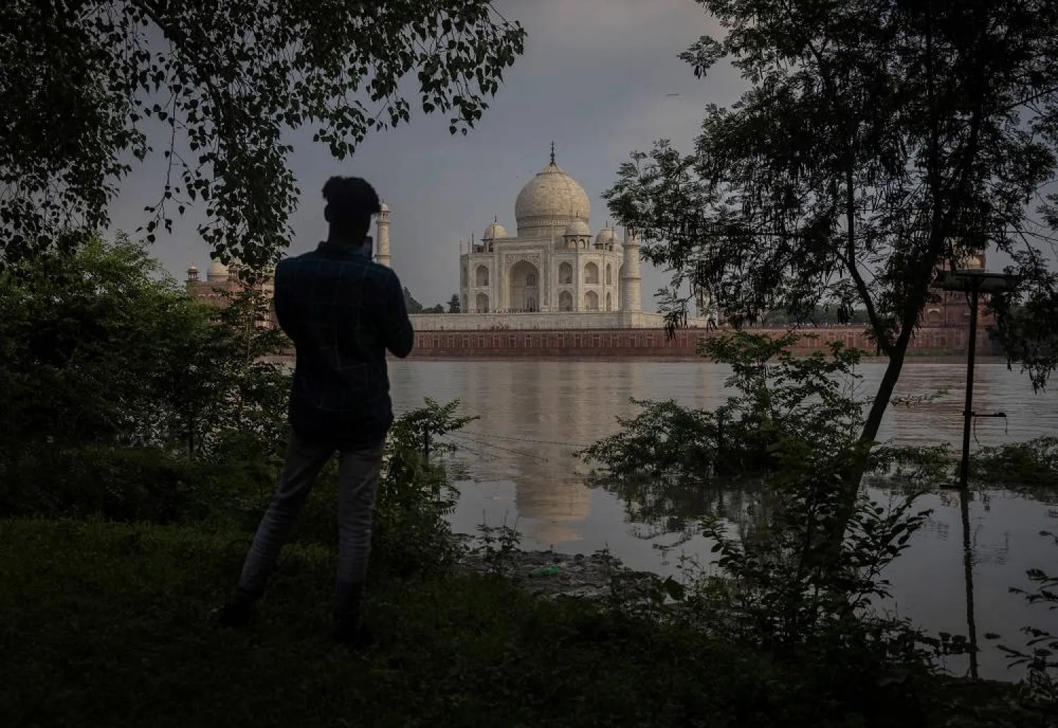 A man takes picture of historic Taj Mahal as the Yamuna River overflows following heavy rains, in Agra, India July 18, 2023. (Reuters)