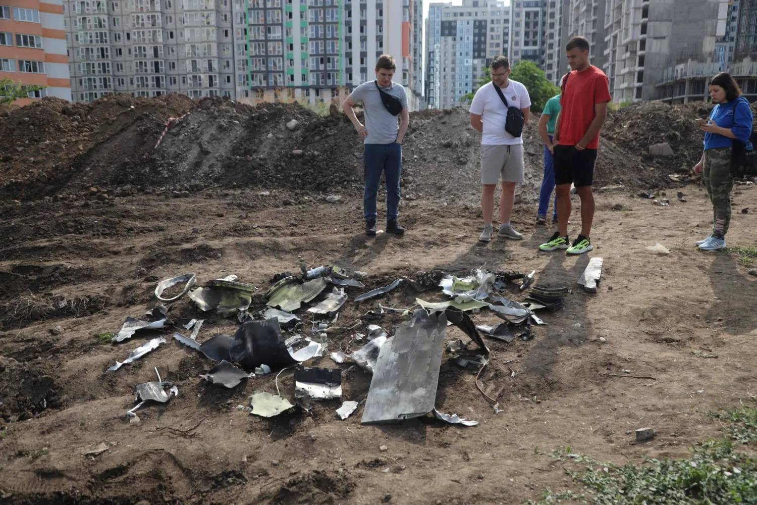 أوكرانيون ينظرون إلى شظايا صاروخ تم إسقاطه خلال غارة ليلية في أوديسا (أ.ف.ب)