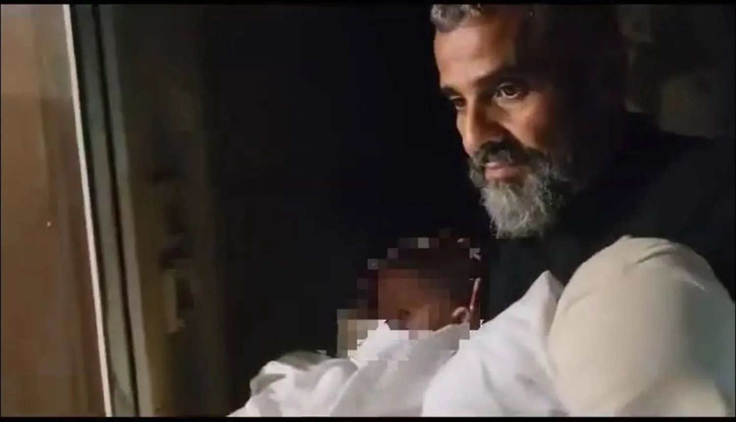 الأب مجدي علاوي يحمل طفلاً عثر عليه في كرتونة