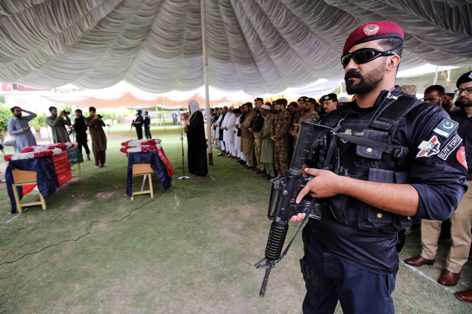 مسؤولون أمنيون باكستانيون وأقارب الضحايا يحضرون مراسم جنازة اثنين من أفراد الشرطة قُتلا عندما فتح مسلحون النار على نقطة تفتيش في حي في بيشاور بباكستان الخميس (إ.ب.أ)