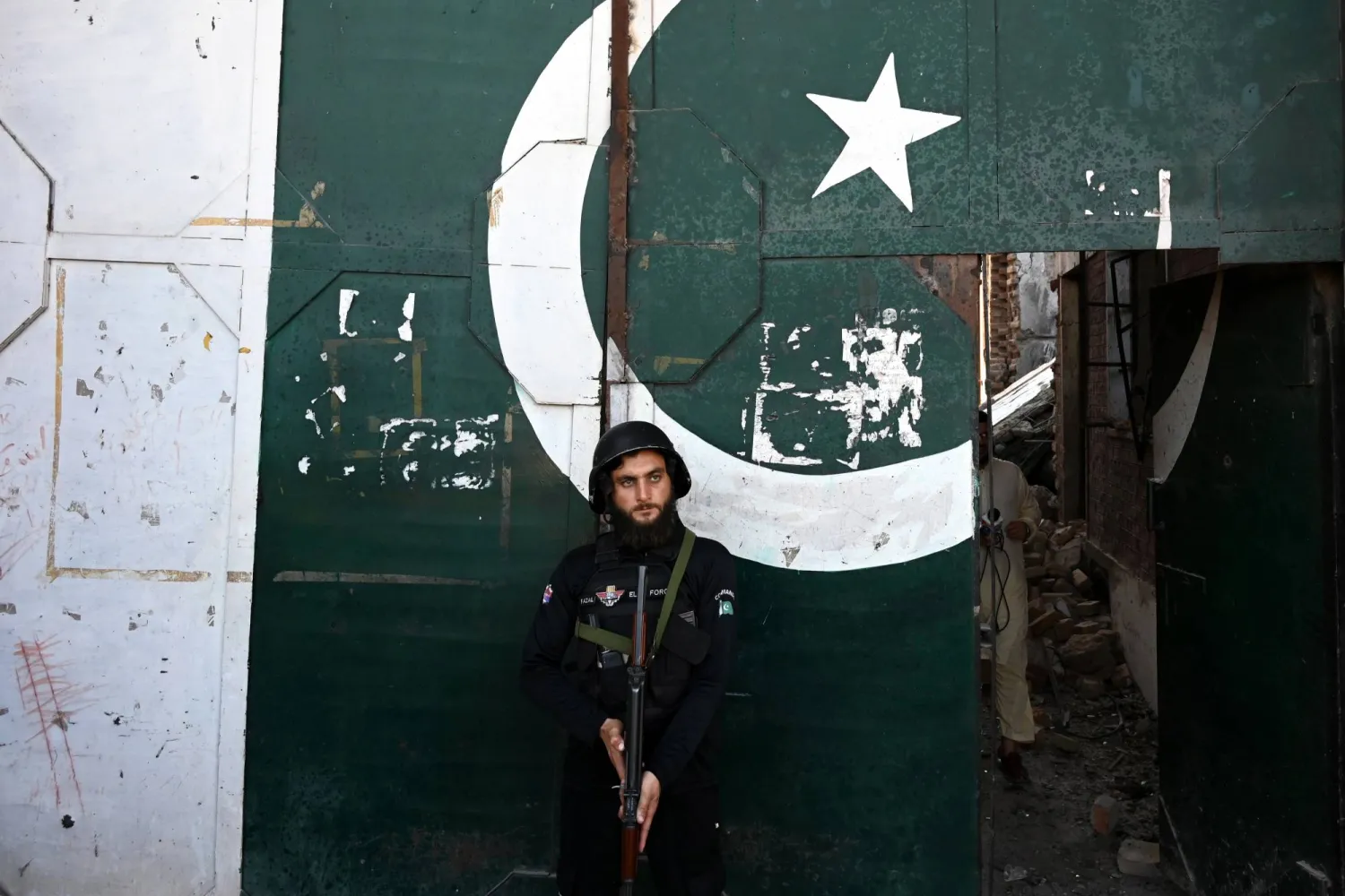 مسؤول أمني باكستاني يقف حارساً في موقع تفجير بمجمع للشرطة قرب الحدود الأفغانية، الخميس (إ.ب.أ)