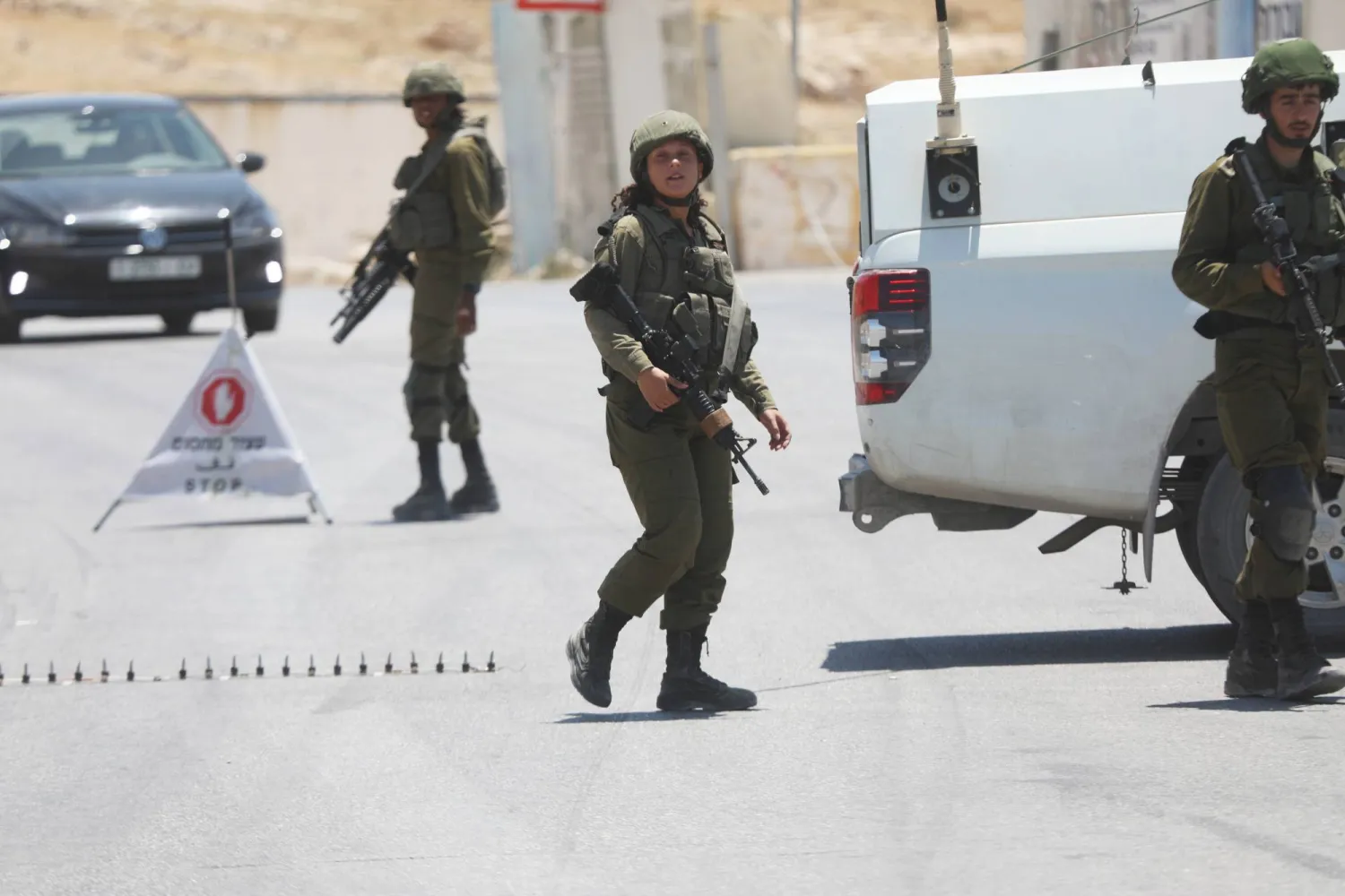 جنود إسرائيليون يقيمون حاجزاً على طريق جنوب بيت لحم بالضفة الغربية (د.ب.أ)