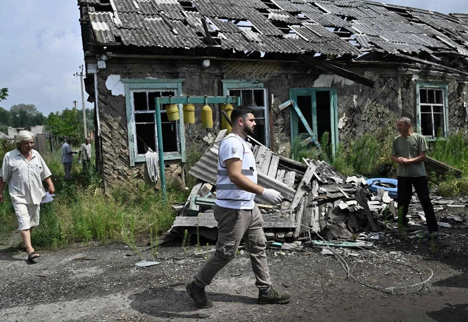 A member of the volunteer medical team walks in front of a destroyed building in Donetsk, Ukraine (AFP)
