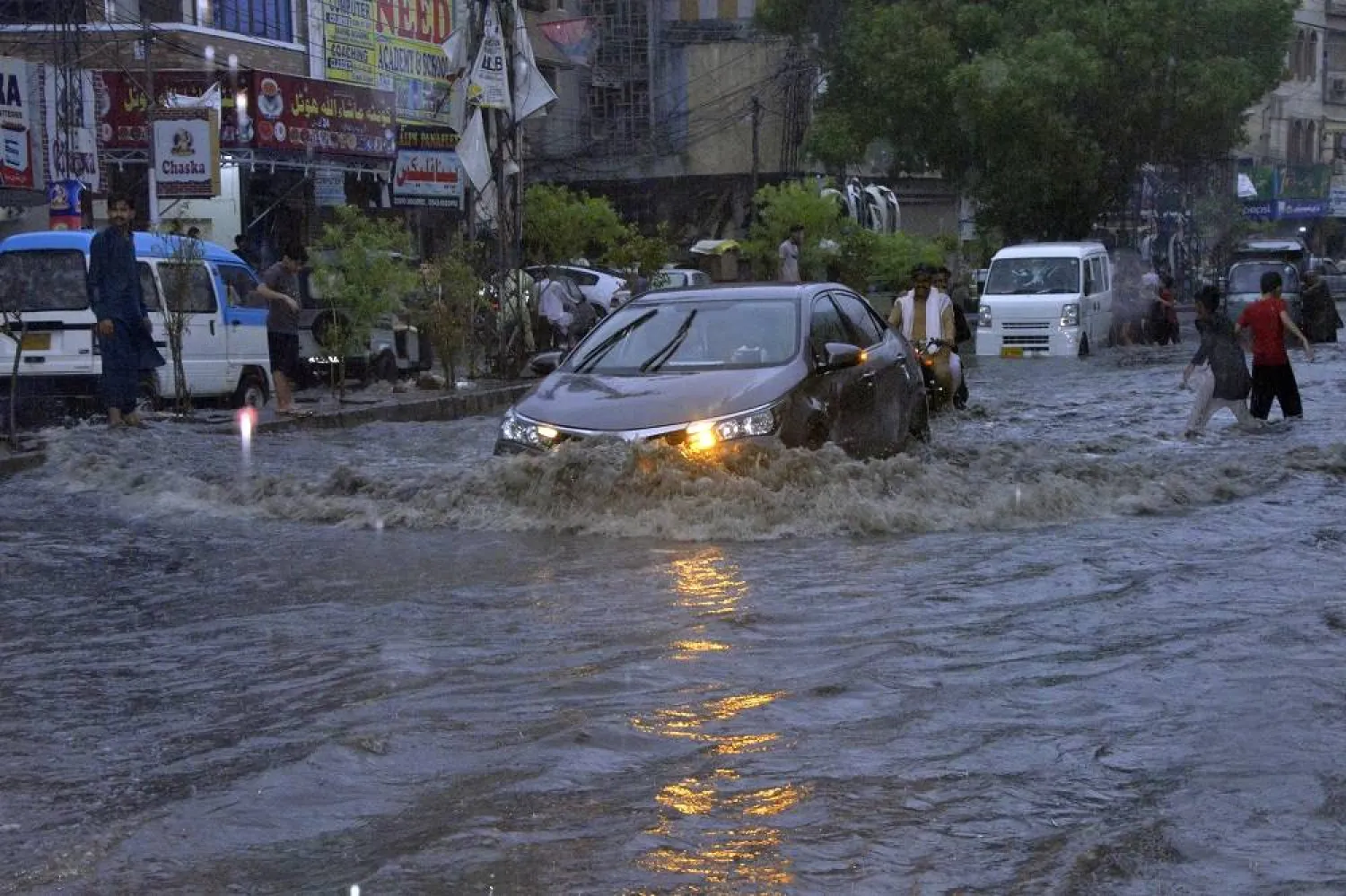 Motorcyclists and cars drive through a flooded road caused by heavy monsoon rainfall in Hyderabad, Pakistan, Sunday, July 23, 2023. (AP)