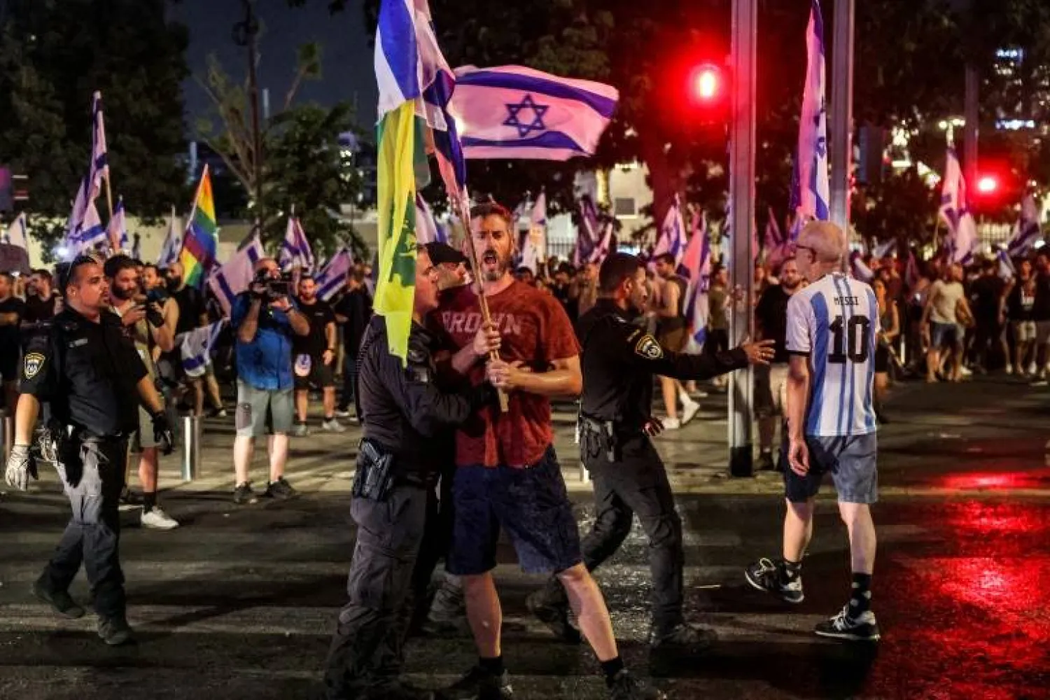 An Israeli riot policeman restrains a demonstrator at a protest in Tel Aviv against the controversial judicial reform vote - JACK GUEZ - AFP