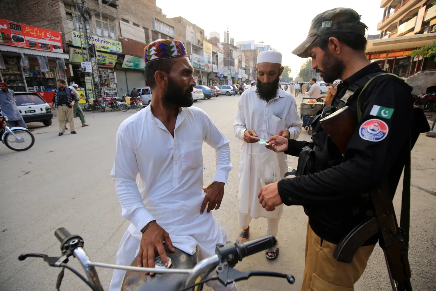 شرطي باكستاني يتفقد هويات المواطنين عند نقطة تفتيش (إ.ب.أ)