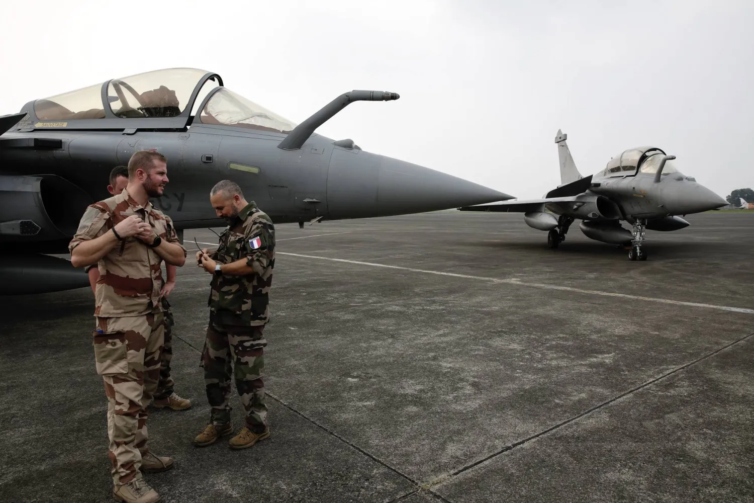 جنود فرنسيون يقفون أمام طائرة مقاتلة فرنسية من طراز "رافال" في قاعدة حليم بيرداناكوسوما الجوية في جاكرتا بإندونيسيا الأربعاء 26 يوليو 2023 (إ.ب.أ)