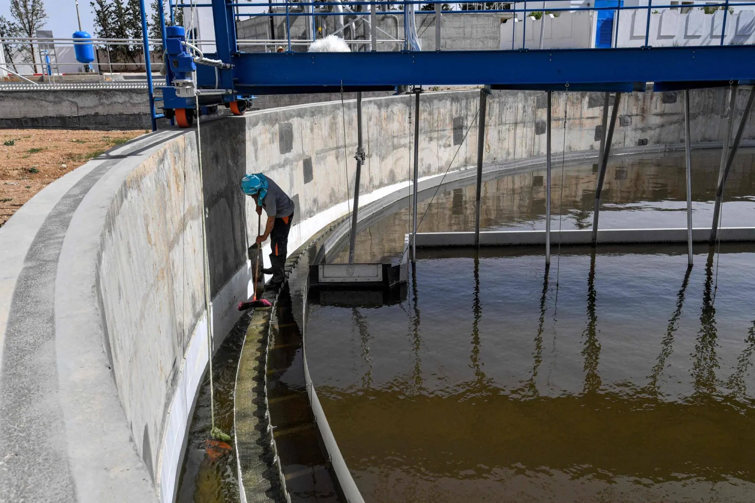 مهندس يقوم بتنظيف جنبات محطة سليانة لمعالجة مياه الصرف الصحي (أ.ف.ب)