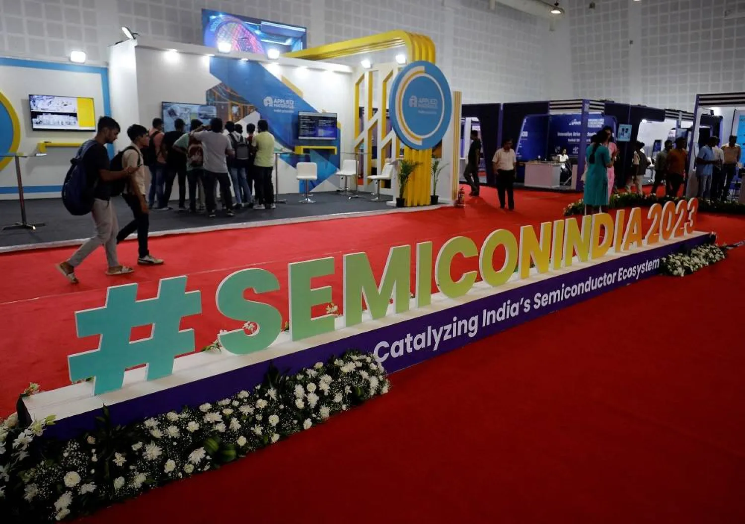 Visitors gather at Applied Materials and Micron Technology kiosks before the start of "SemiconIndia 2023", India's annual semiconductor conference, in Gandhinagar, India, July 25, 2023. (Reuters)
