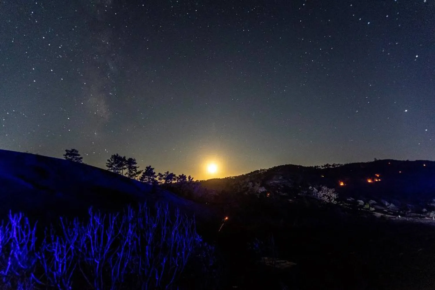 The moon rises behind burned hills, as a wildfire burns, near the village of Asklipieio, on the island of Rhodes, Greece, July 28, 2023. (Reuters)