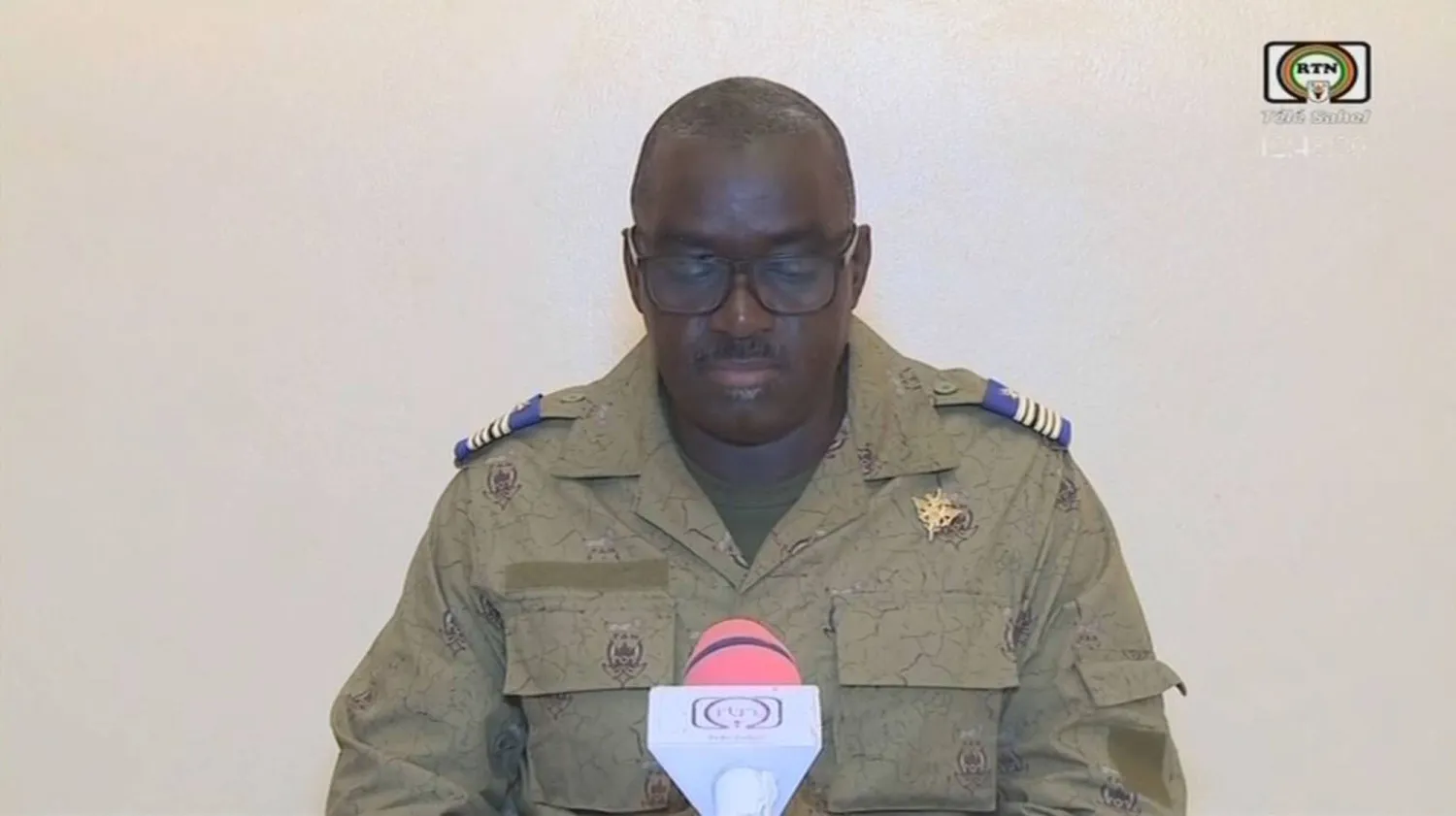 الكولونيل في جيش النيجر أمادو عبد الرحمن يتلو بياناً صحافياً في التلفزيون الوطني الجمعة 28 يوليو 2023 (أ.ف.ب)