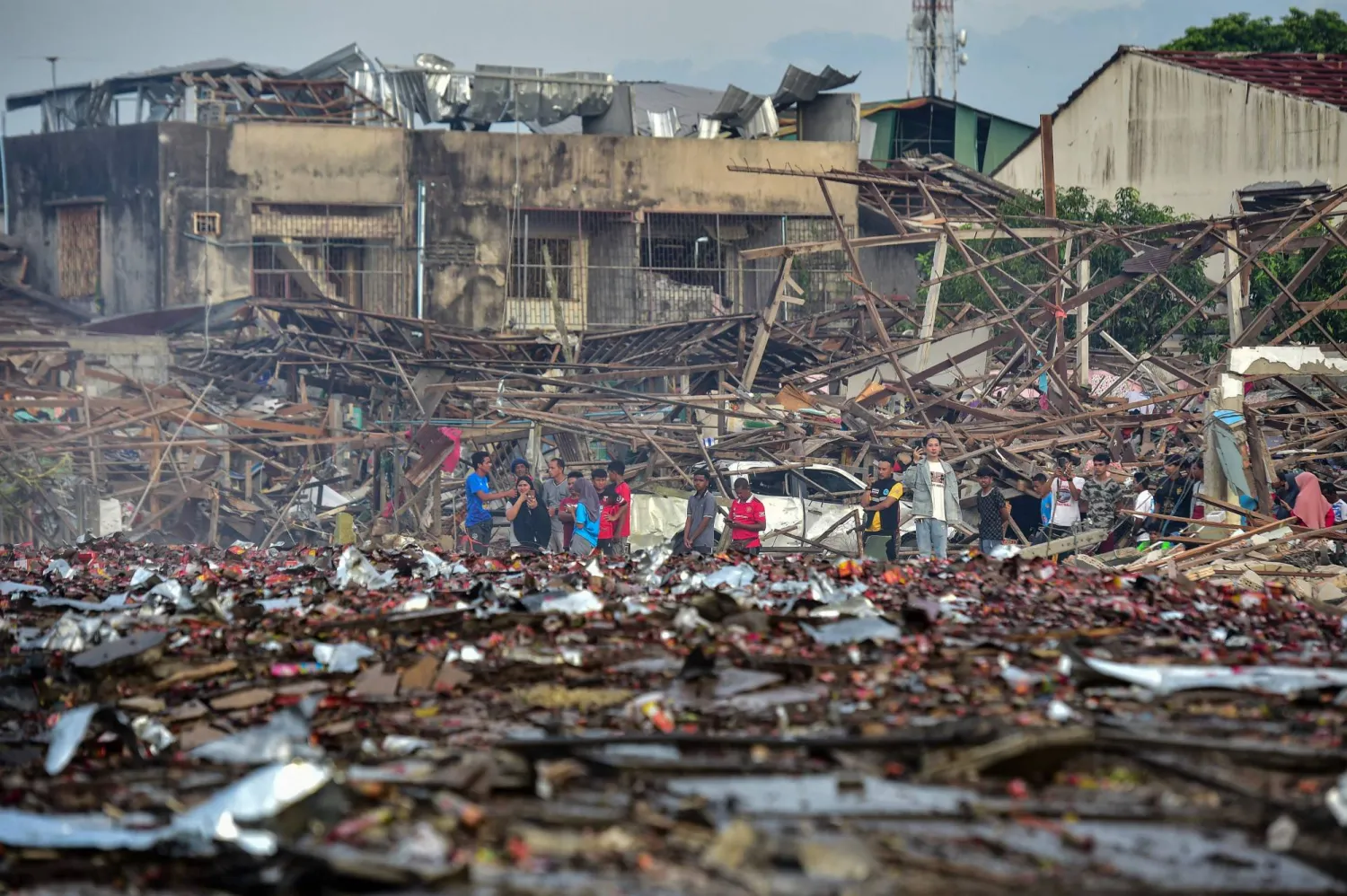 People look at the aftermath of destroyed homes after an explosion ripped through a firework warehouse in Sungai Kolok district in the southern Thai province of Narathiwat on July 29, 2023. (Photo by Madaree TOHLALA / AFP)
