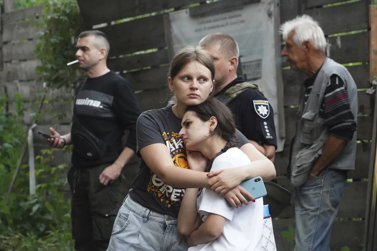 فتاتان أوكرانيتان أمام مبنى دمر في قصف روسي على مدينة سومي الأوكرانية (أ.ب)