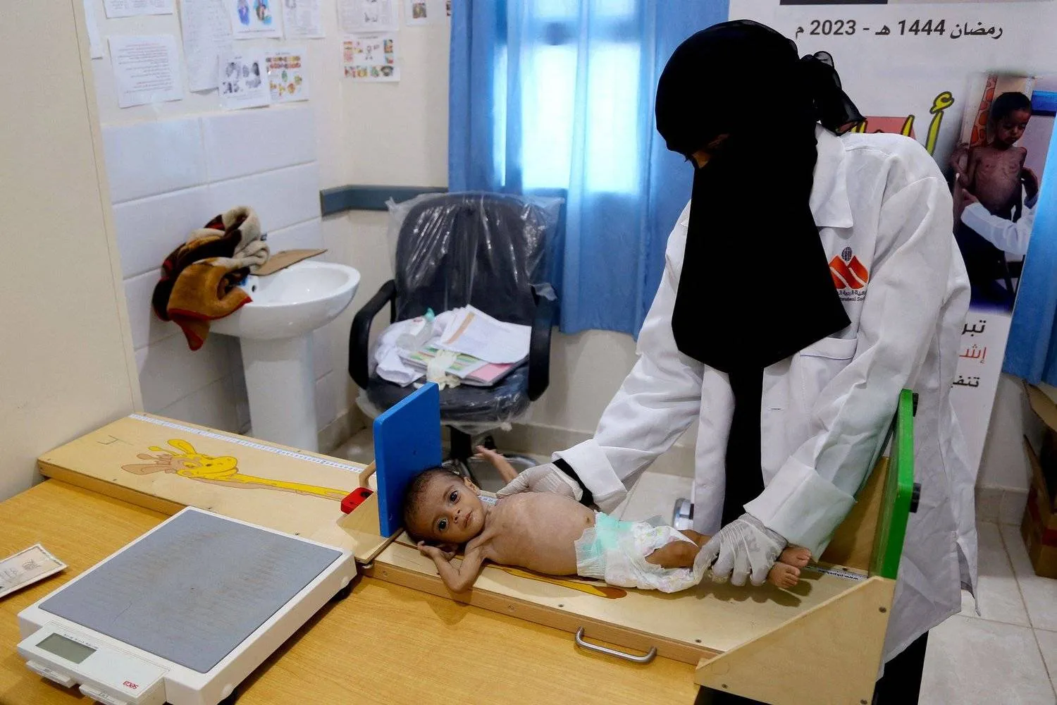 A Yemeni doctor checks a girl suffering from acute malnutrition (AFP)
