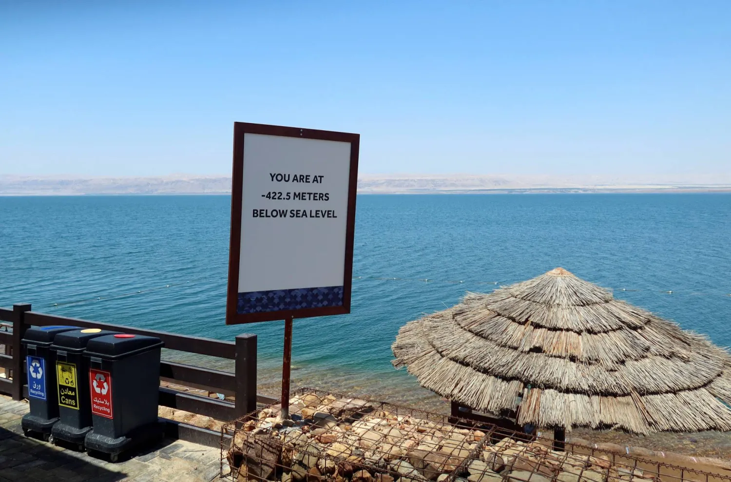 يافطة على أحد شواطئ البحر الميت في الأردن تقول «أنت هنا 422,5 متر تحت سطح البحر» (رويترز)