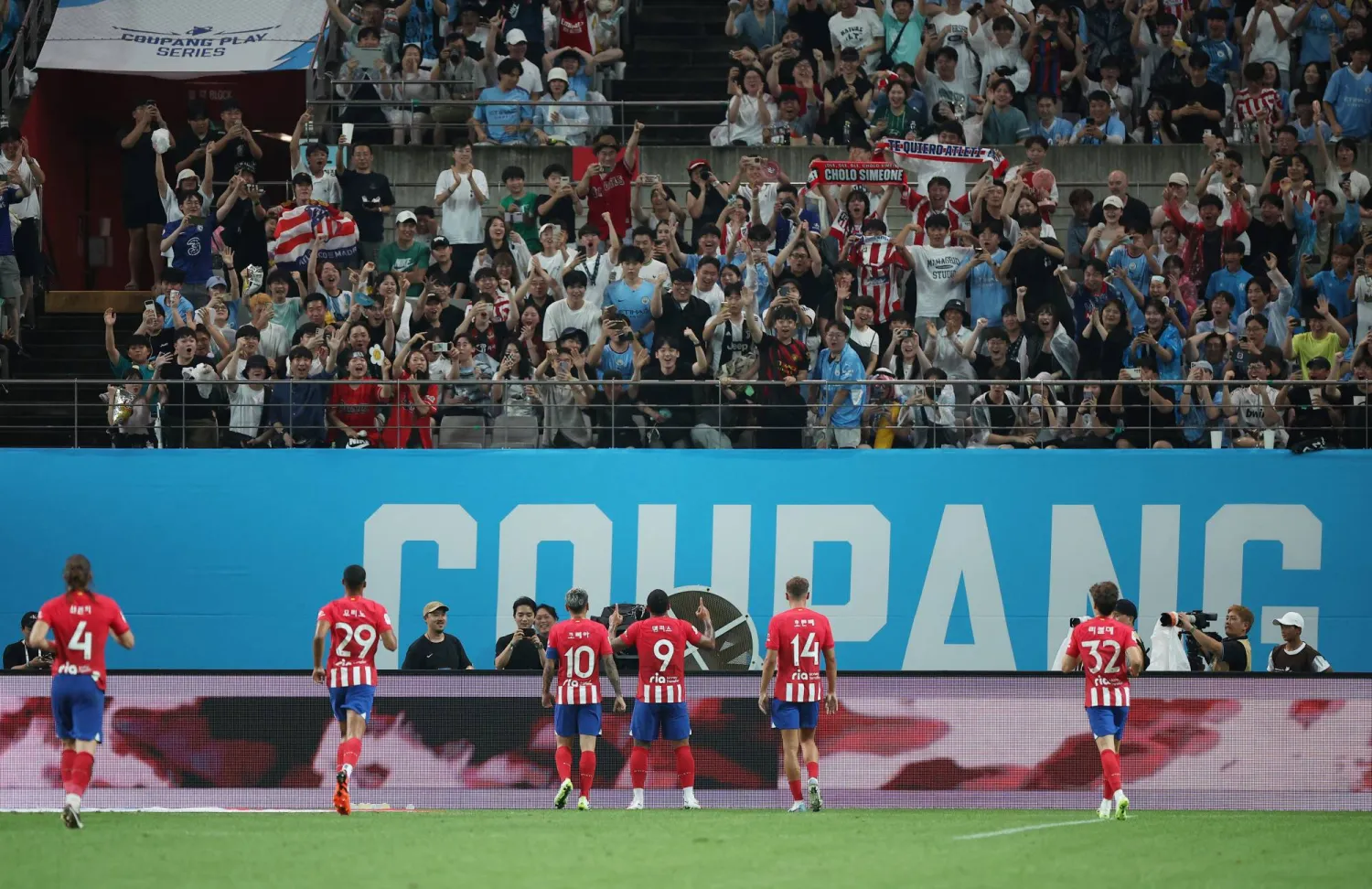 لاعبو أتلتيكو مدريد يحيون مشجعيهم بعد الفوز بالمباراة (رويترز)