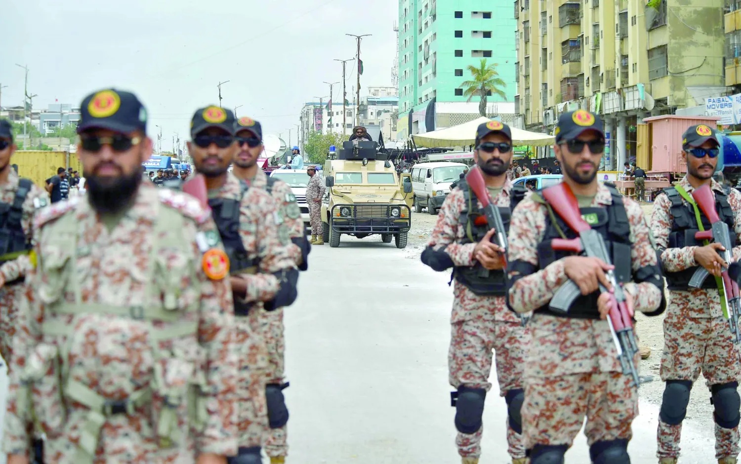 مسؤولون أمنيون باكستانيون يقفون حراسة على طول طريق موكب خلال يوم عاشوراء في كراتشي بباكستان (إ.ب.أ)