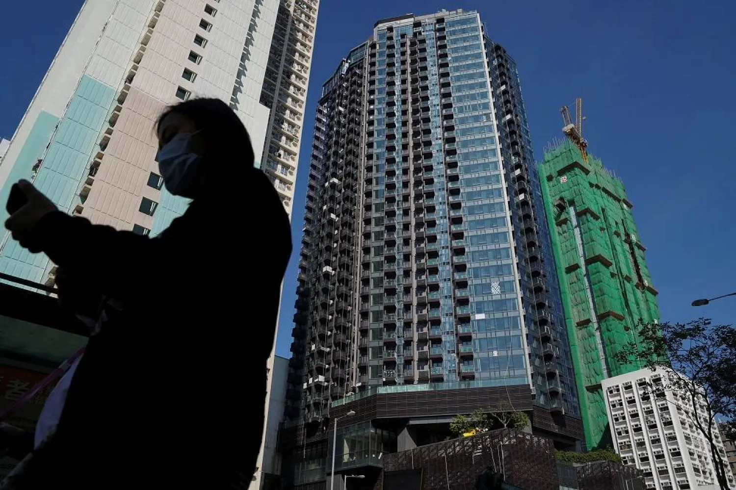 A pedestrian walks past a residential development in Hong Kong, China, November 27, 2021. (Reuters)