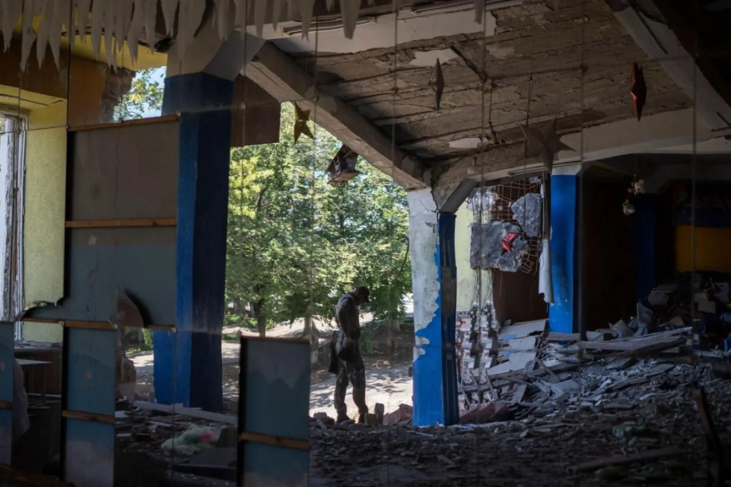 Bir Ukrayna askeri, Kupyansk'ta daha önce dans salonu olarak kullanılan bir binayı inceliyor (AP)