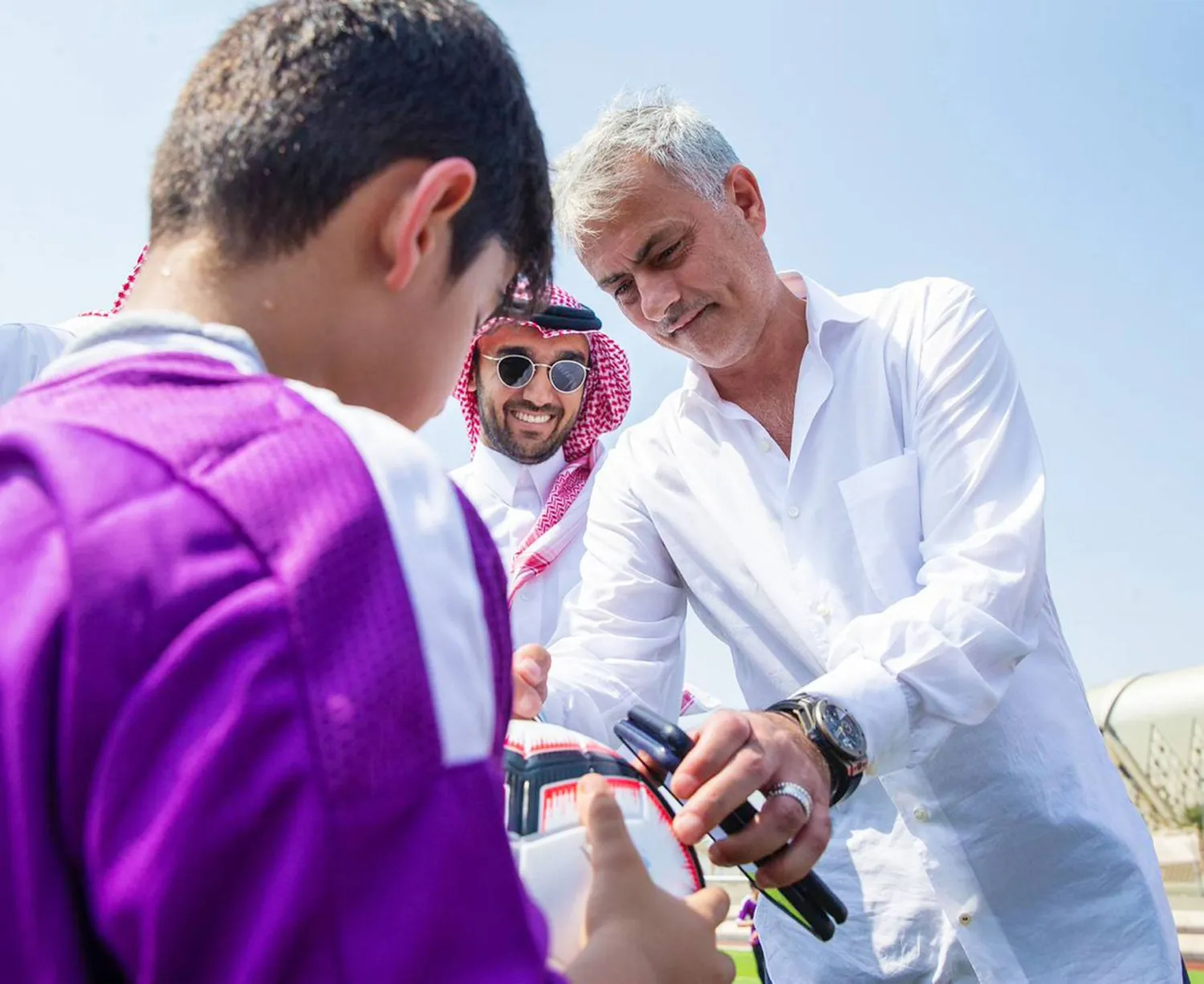 مورينيو يوقع الكرة لأحد اللاعبين الصغار في زيارة سابقة للسعودية (تصوير: محمد المانع)
