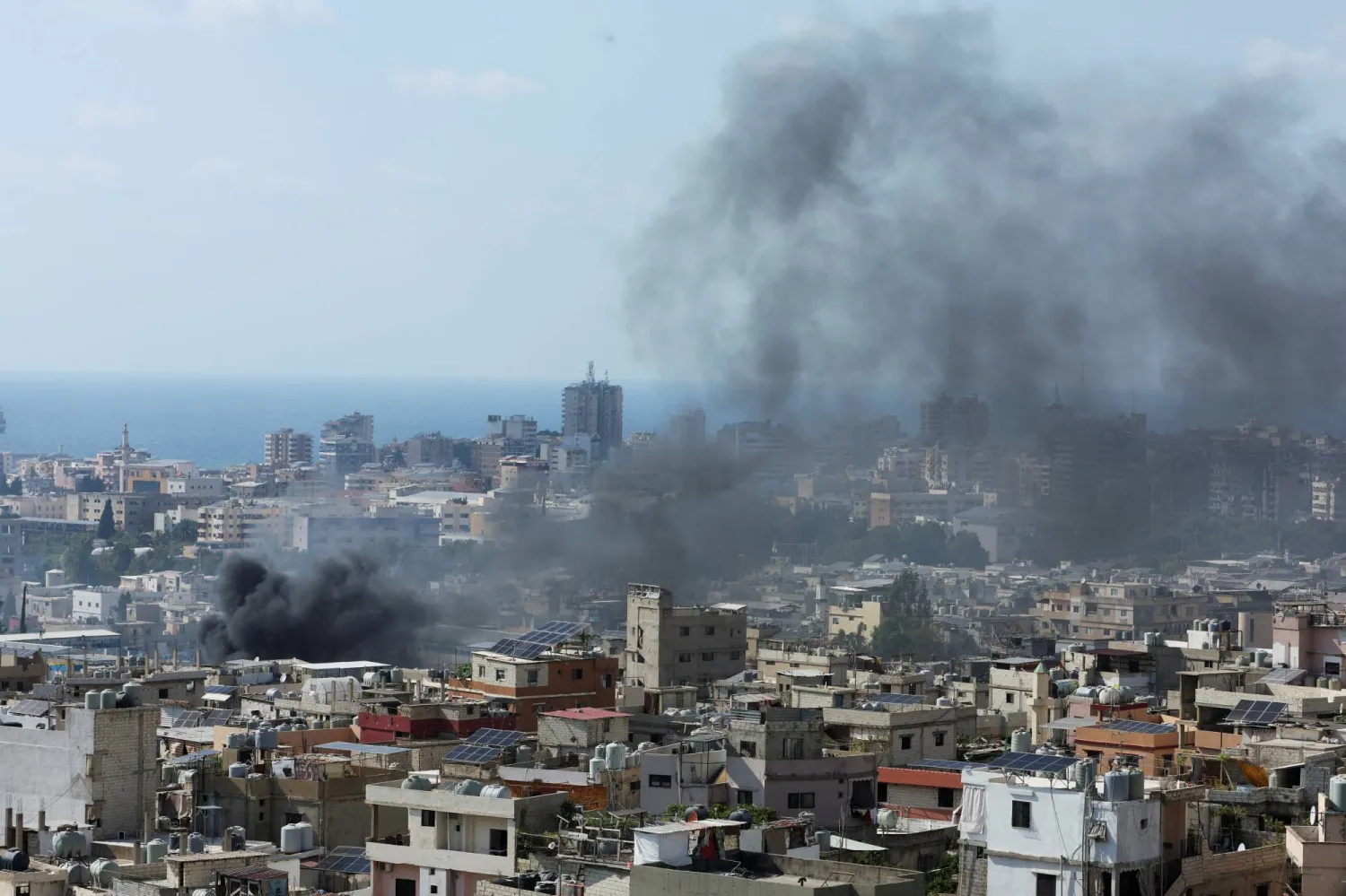 تصاعد الدخان فوق مخيم عين الحلوة جراء الاشتباكات بين الفصائل الفلسطينية (رويترز)