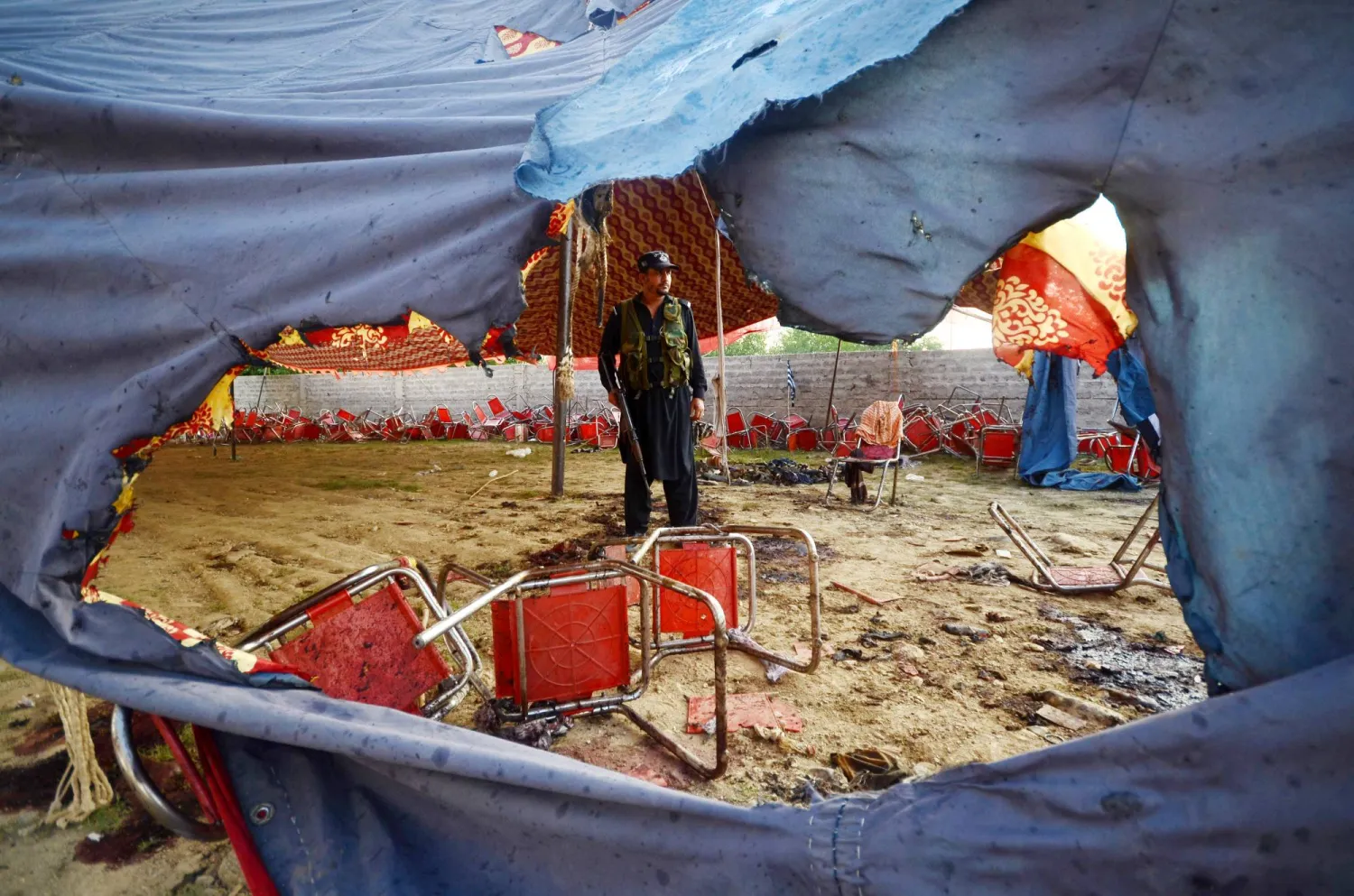 مسؤول أمني يتفقد موقع تفجير في خار حيث  قُتل ما لا يقل عن 56 شخصًا وأصيب العشرات في هجوم انتحاري استهدف مؤتمرًا عماليًا للحزب السياسي الإسلامي (جمعية علماء الإسلام) (د.ب.أ)