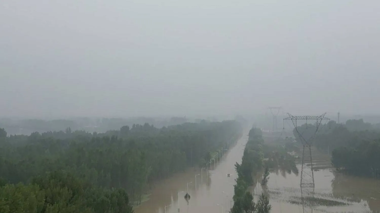 An aerial view shows people riding a boat through a flooded road after the rains and floods brought by remnants of Typhoon Doksuri, in Zhuozhou, Hebei province, China, in this screengrab taken from a Reuters video shot August 3, 2023. (Reuters TV via Reuters)
