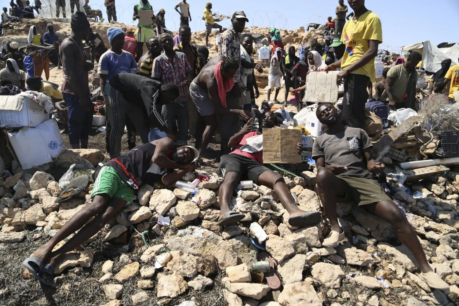 عدد من المهاجرين غير الشرعيين العالقين على الحدود التونسية - الليبية (أ.ب)