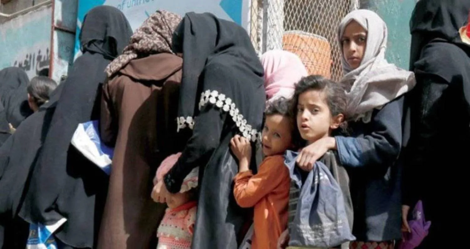 Yemeni women line up in front of an association in Sanaa to receive food assistance. (EPA)