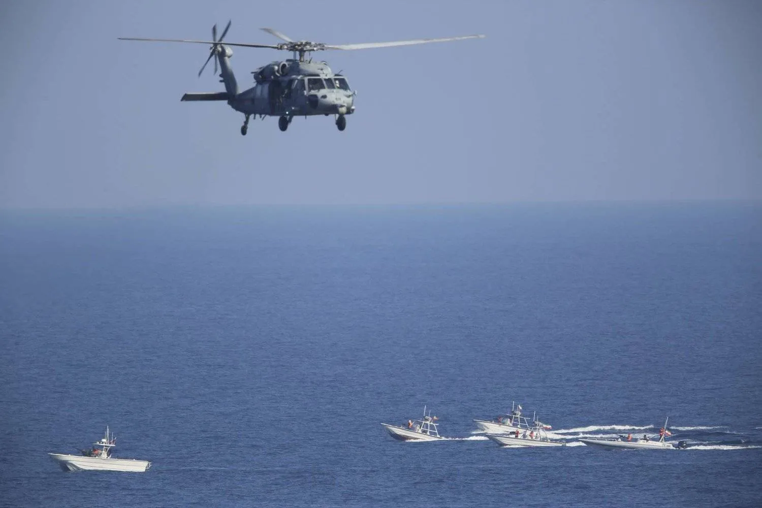 An HH60-C Pave Hawk helicopter flies over Iranian Revolutionary Guard patrol boats in the Strait of Hormuz last December (AP)
