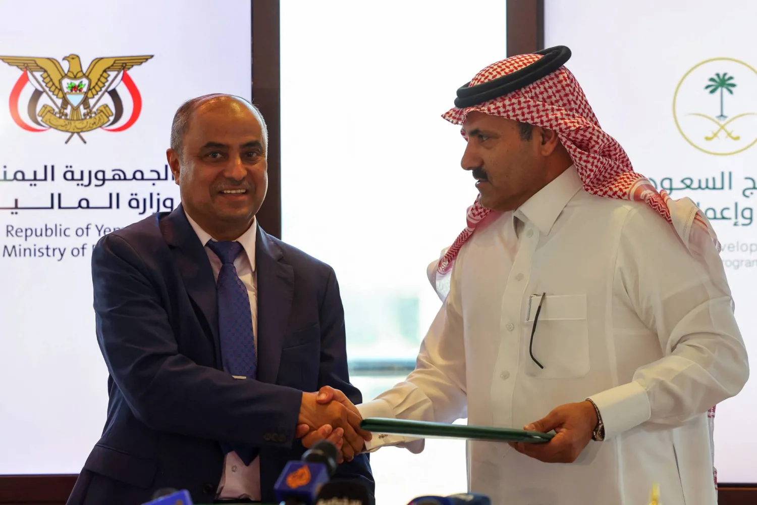 السفير السعودي محمد آل جابر بعد توقيعه مع وزير المالية اليمني اتفاقية الدعم الجديد (أ.ف.ب)