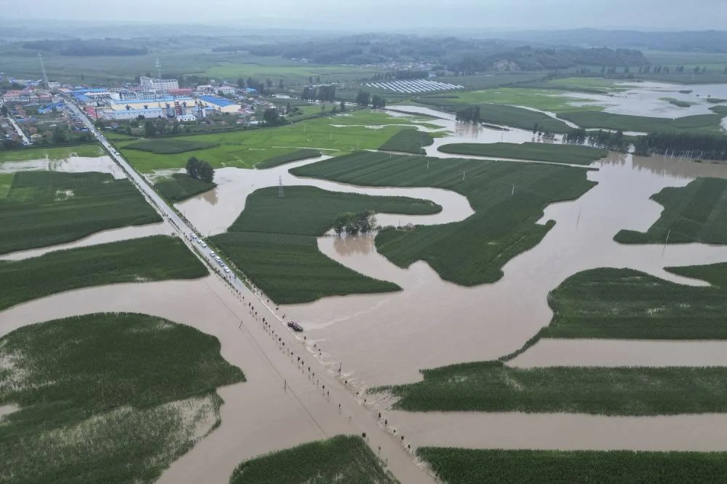 In this aerial photo released by Xinhua News Agency, flood waters course through fields and roads in Kaiyuan Town of Shulan in northeastern China's Jilin Province on Friday, Aug. 4, 2023. (Xinhua via AP)
