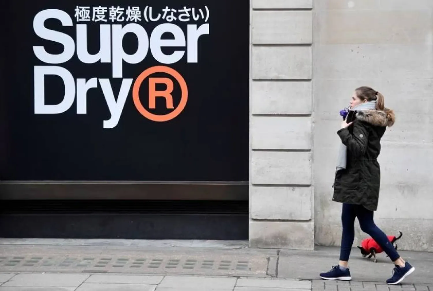 A woman walks past a window display at a Superdry store in London, Britain, March 1, 2019. REUTERS/Toby Melville/File Photo