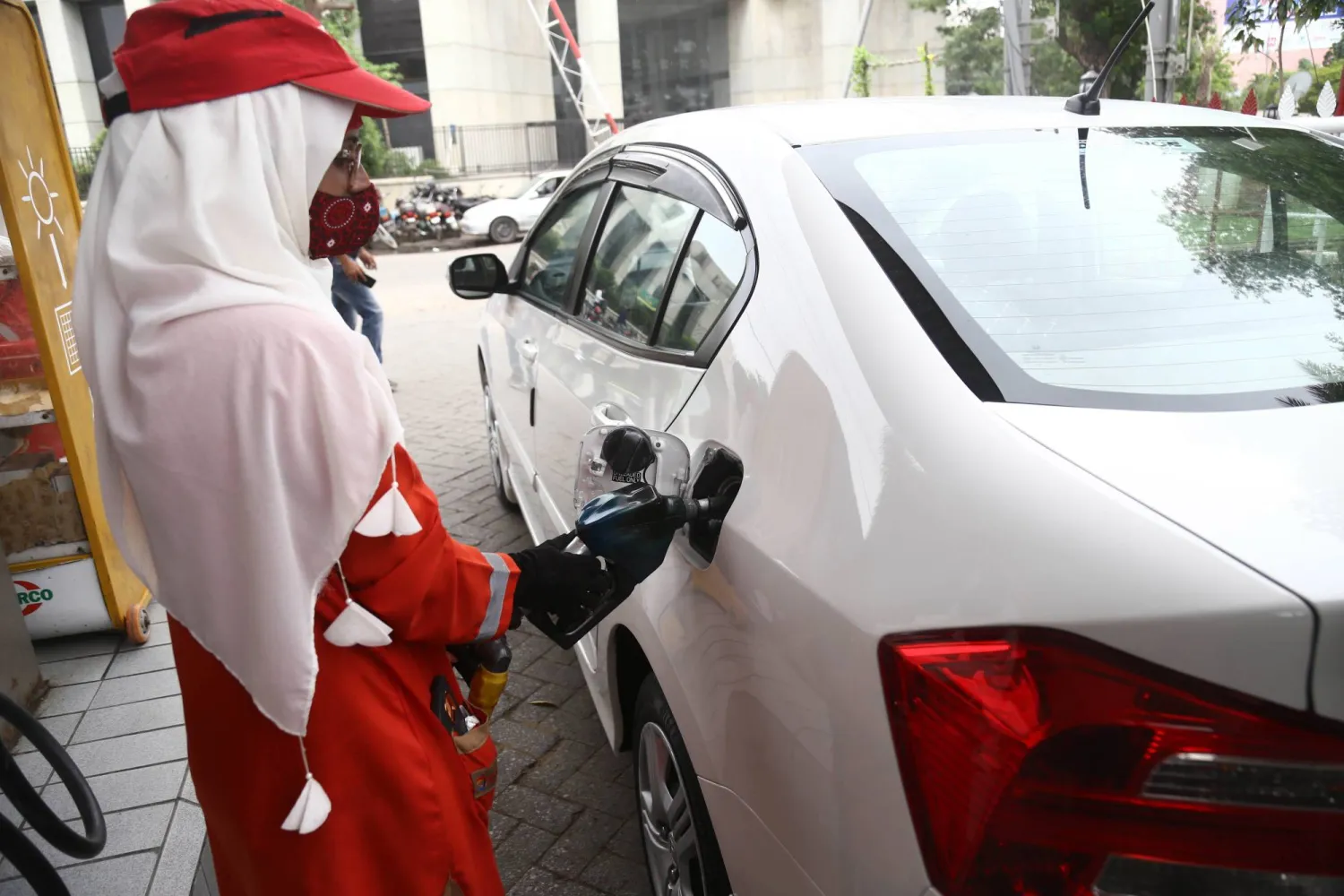 سيدة تملأ سيارة بالغاز في كاراتشي بباكستان (إ.ب.أ)