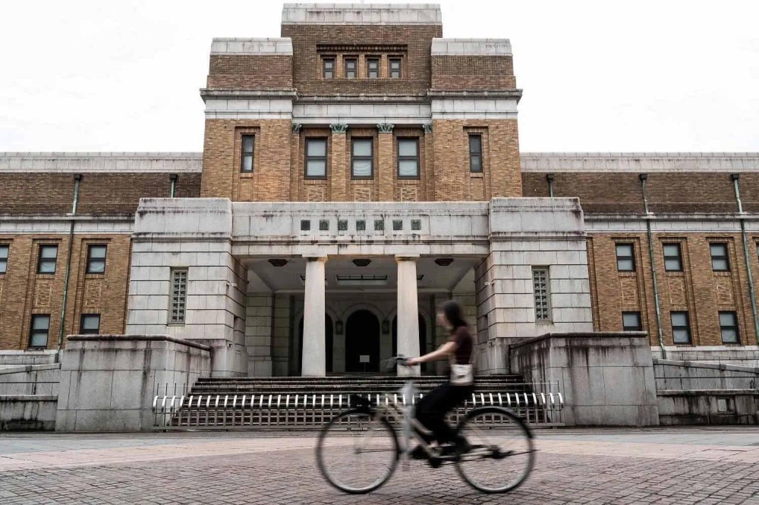 A woman rides her bicycle past the National Museum of Nature and Science at Ueno Park in Tokyo on August 9, 2023. (AFP)