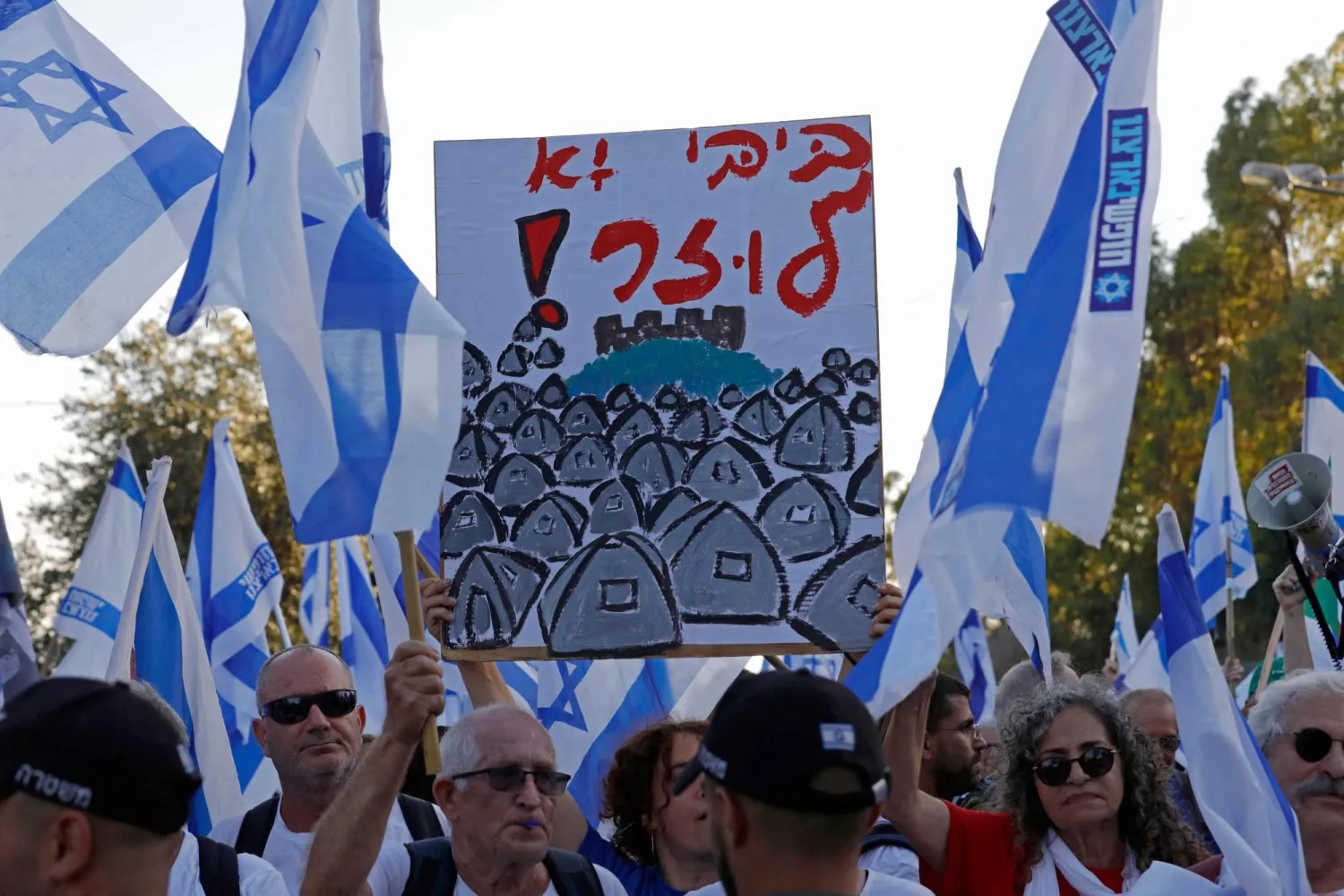  متظاهرون في مستوطنة نيفيه أتيف في الجولان حيث يقضي نتنياهو وزوجته أياماً للاستجمام (أ.ف.ب)