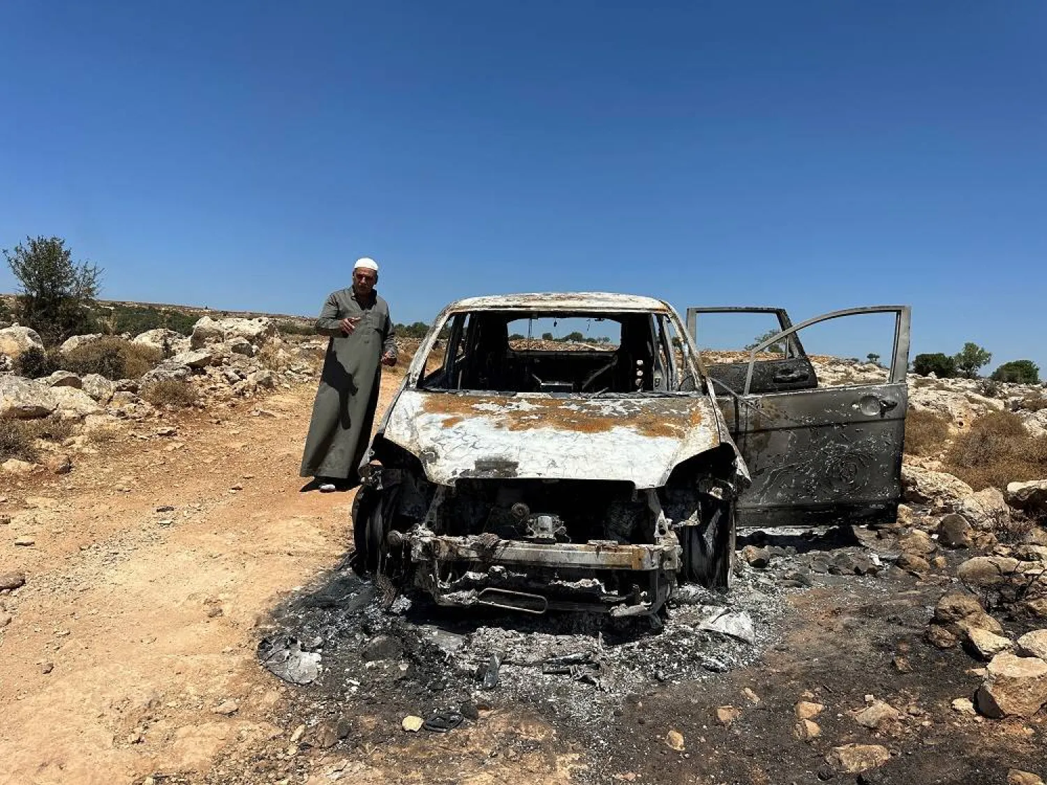  Palestinian Saber Asaliyyeh reacts near a burned car after a confrontation with a group of Israeli settlers in Burqa near Ramallah in the Israeli-occupied West Bank, August 9, 2023. (Reuters)