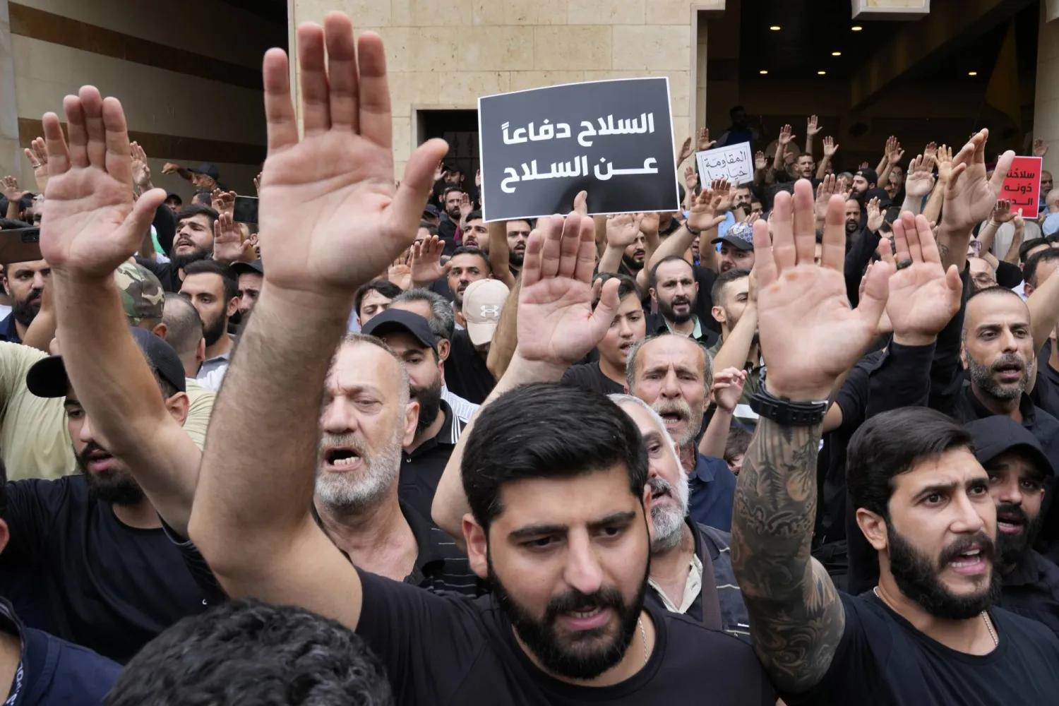 «السلاح دفاعاً عن السلاح»... الشعار الذي رفعه عناصر «حزب الله» خلال تشييع أحد رفاقهم الذي قتل في اشتباك بلدة الكحالة (أ.ب)
