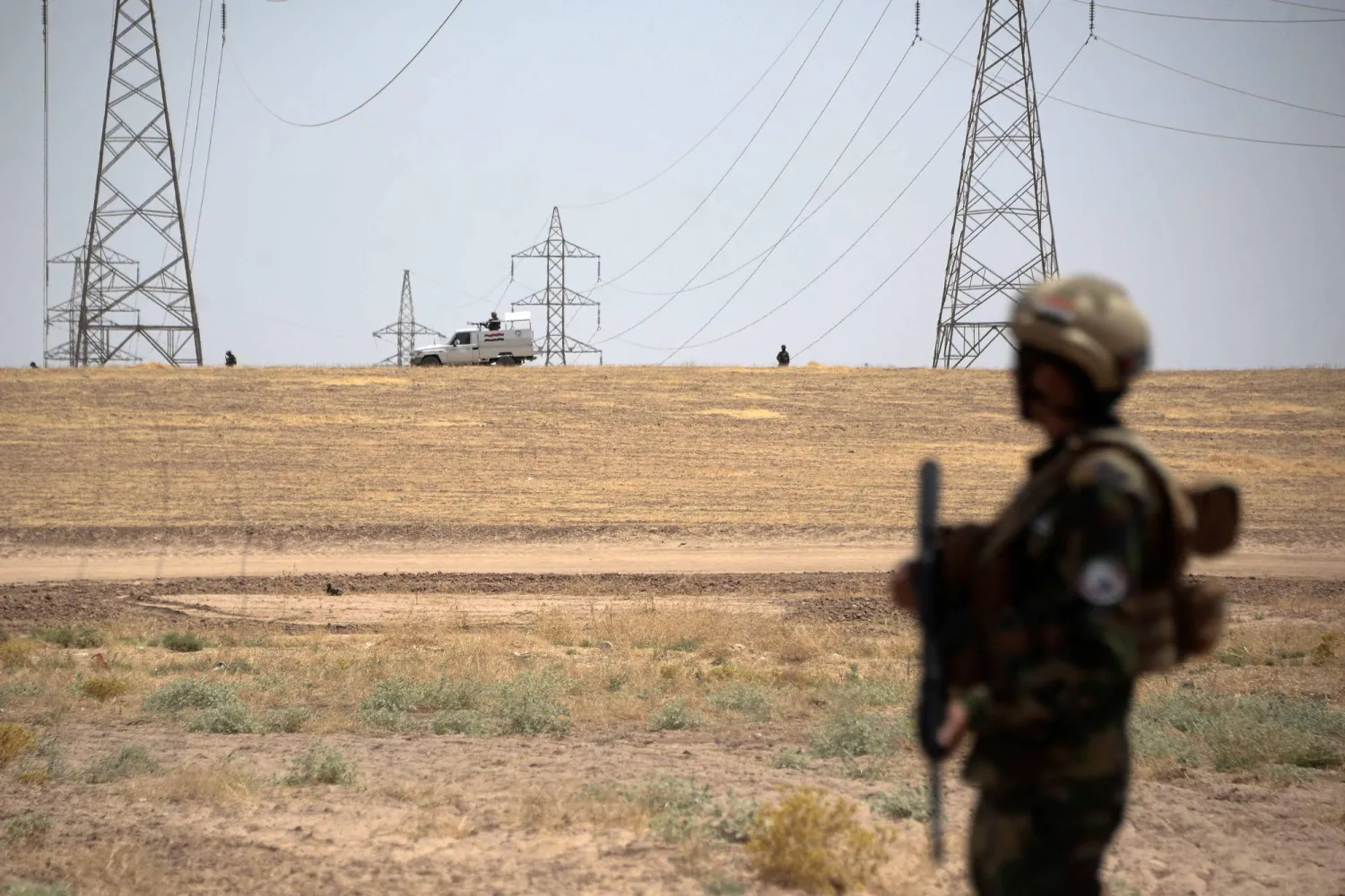  عنصر من «الحشد الشعبي» يحرس محطة تحويل كهربائي في محافظة نينوى (أ.ف.ب)