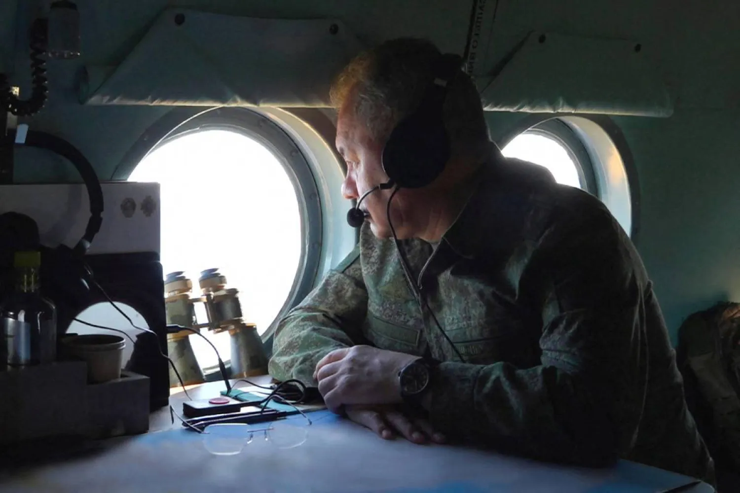 شويغو ينظر عبر نافذة طائرة مروحية خلال رحلته إلى الأسطول الشمالي (رويترز)