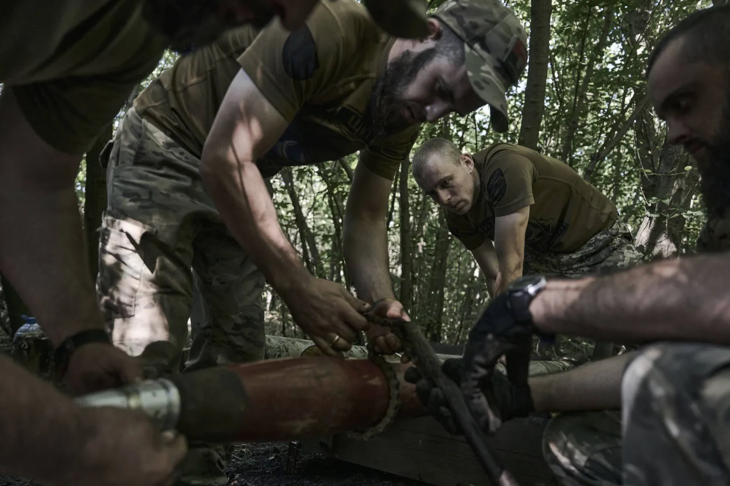 جنود أوكرانيون يقومون بتحضير قذيفة قرب مدينة باخموت الأوكرانية (أ.ب)