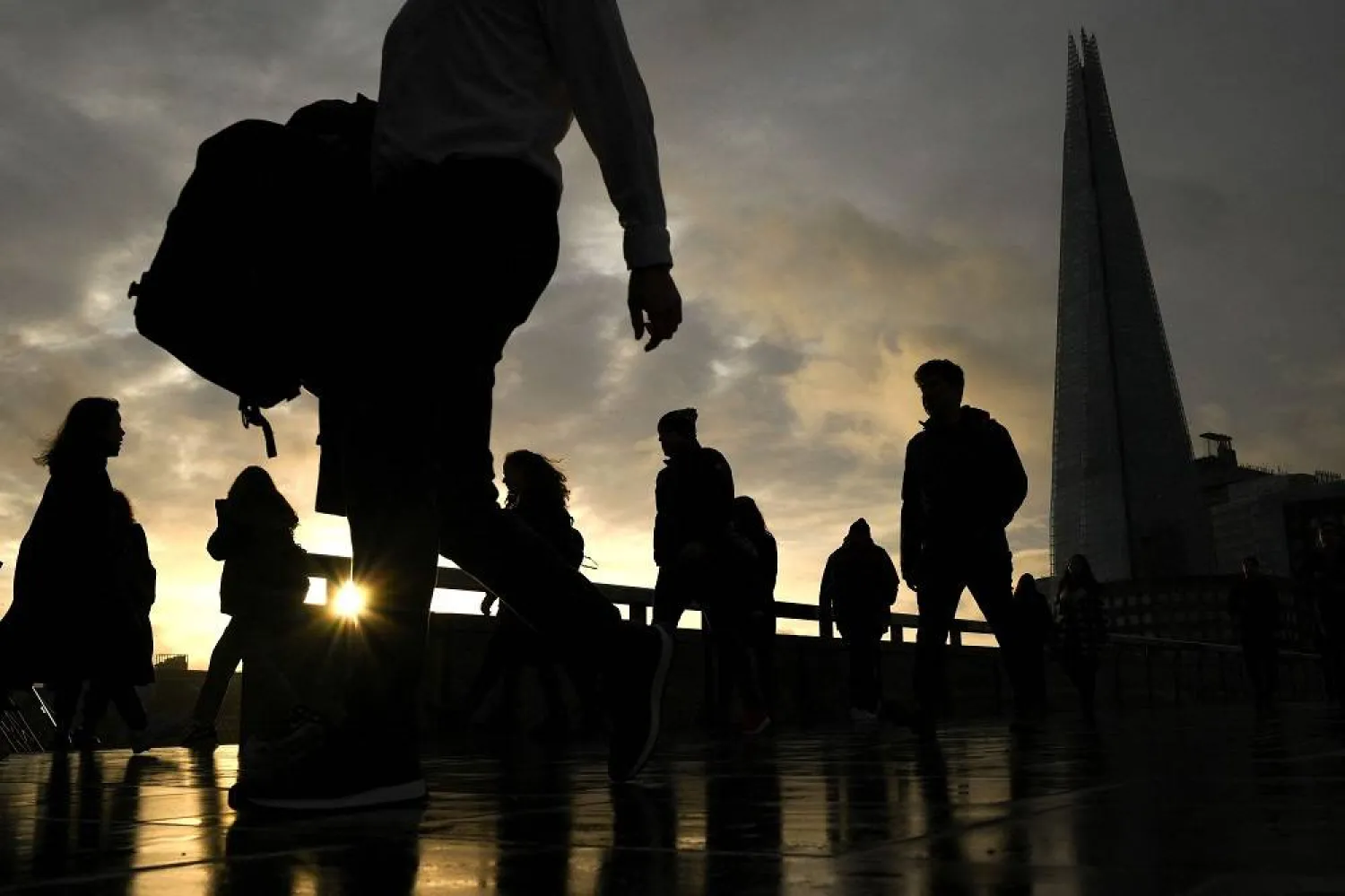 Commuters on their way to work cross London Bridge in central London on January 3, 2023. (AFP)