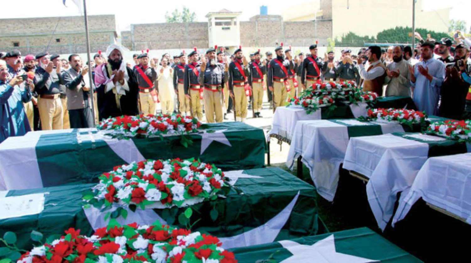 مسؤولون أمنيون وأقارب يحضرون مراسم جنازة رجال الشرطة الذين قُتلوا بانفجارين في سوات بباكستان حيث قتل ما لا يقل عن 17 شخصاً وأصيب أكثر من 50 آخرين 26 أبريل 2023 (إ.ب.أ)