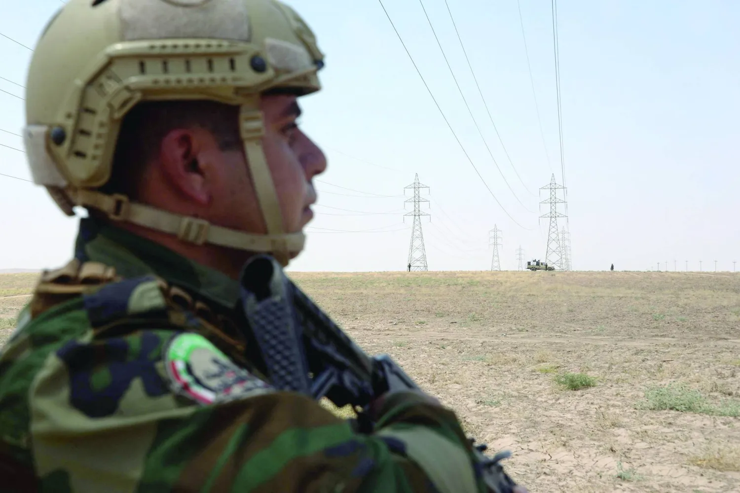 عناصر في «الحشد الشعبي» يحرسون أبراج الكهرباء في بادوش بمحافظة نينوى في شمال العراق (أ.ف.ب)