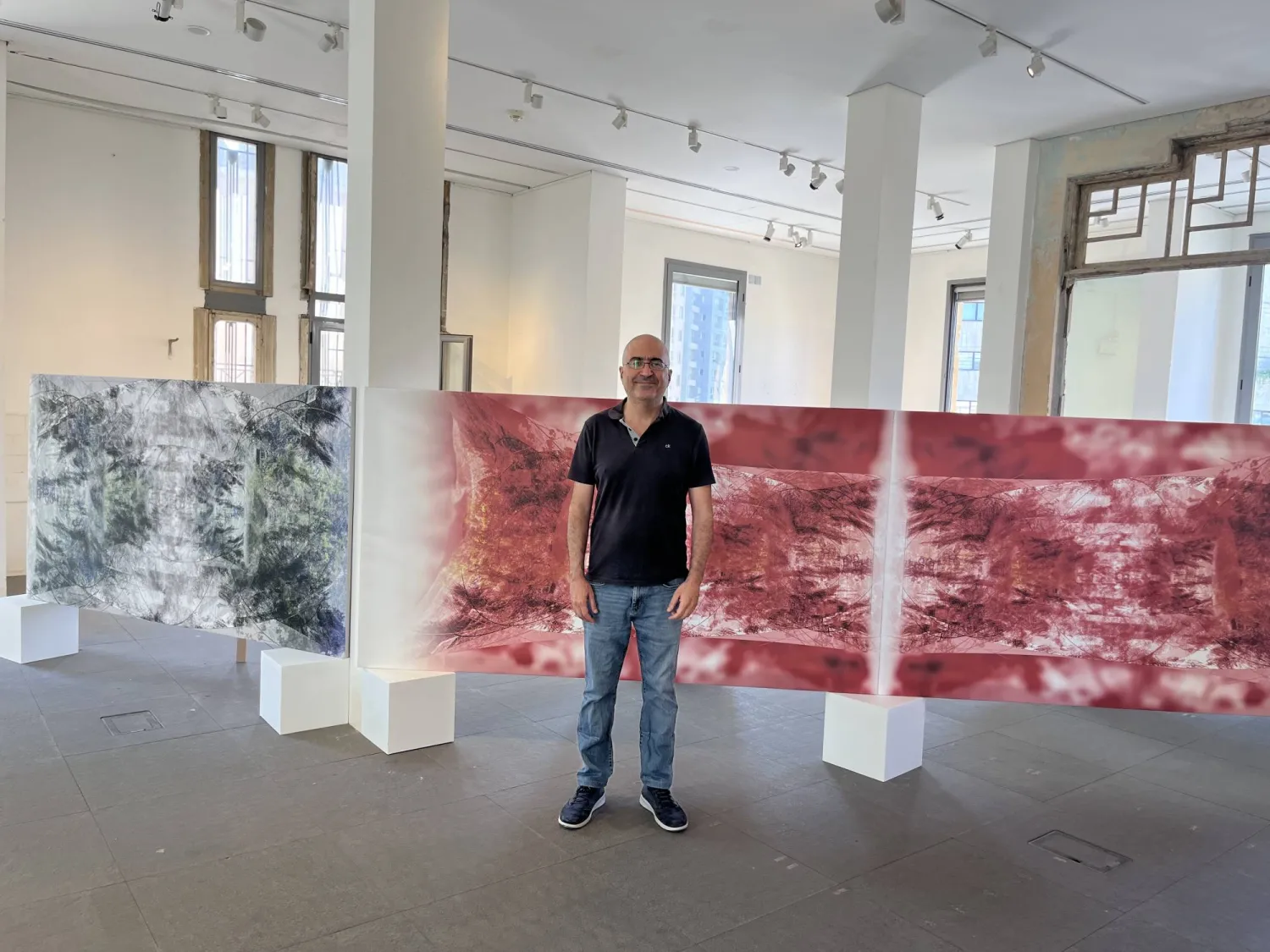 رالف الحاج أمام لوحته «صار شي» (الشرق الأوسط)